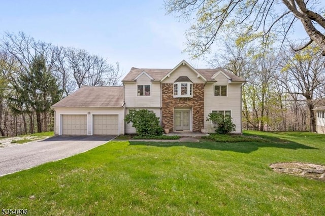 view of front of home with an attached garage, a front lawn, driveway, and stone siding