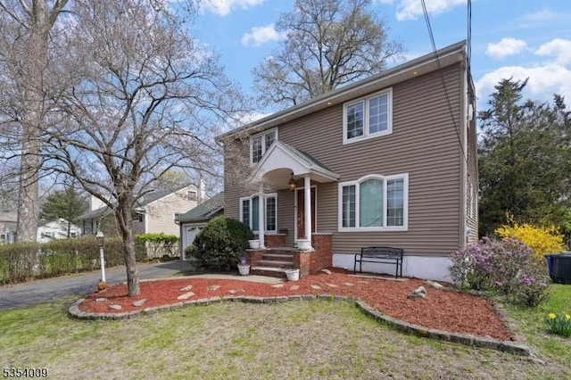 view of front of property featuring driveway, a front lawn, and a garage