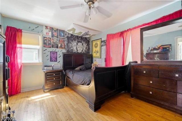 bedroom with baseboards, multiple windows, wallpapered walls, and hardwood / wood-style flooring