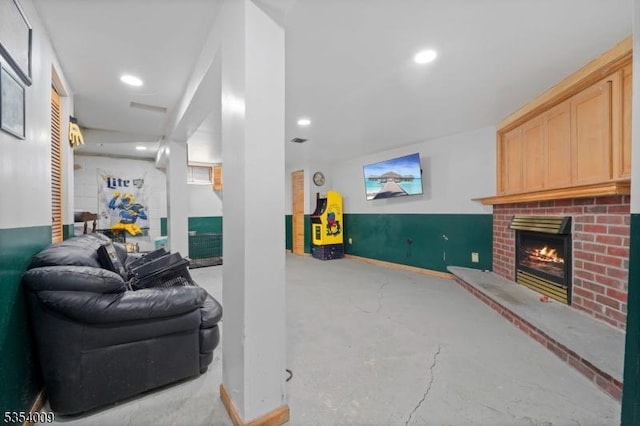 living area with a brick fireplace, recessed lighting, and finished concrete floors