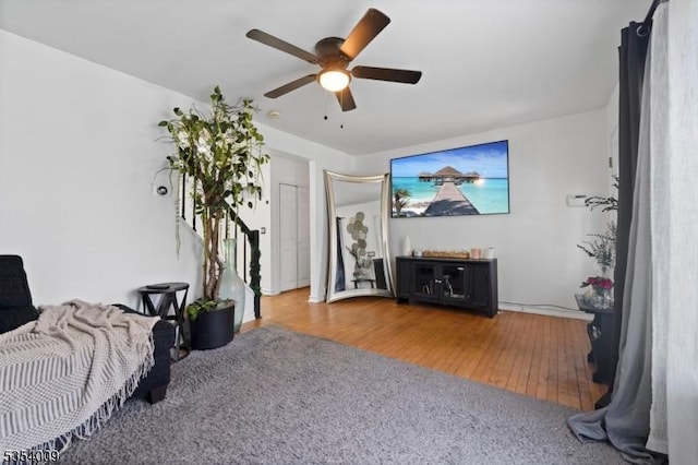 living area featuring a ceiling fan and wood finished floors