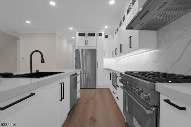 kitchen featuring recessed lighting, light stone countertops, a sink, stainless steel appliances, and extractor fan