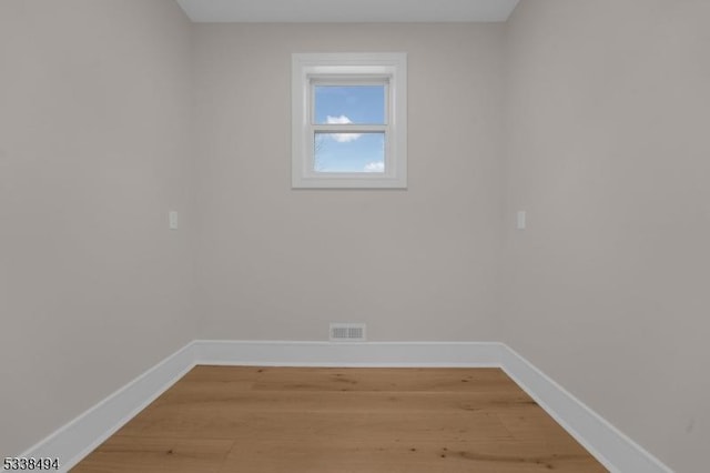 spare room with visible vents, light wood-style flooring, and baseboards