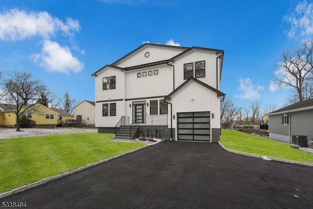 view of front of home with a front lawn, aphalt driveway, cooling unit, and an attached garage