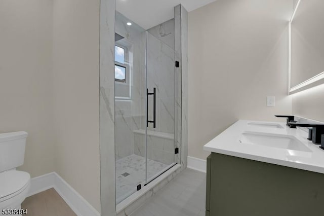 bathroom featuring recessed lighting, vanity, toilet, a marble finish shower, and baseboards