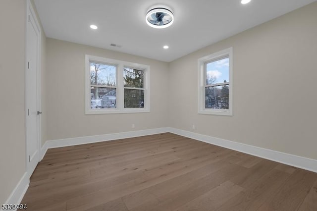 unfurnished room featuring baseboards, recessed lighting, and wood finished floors