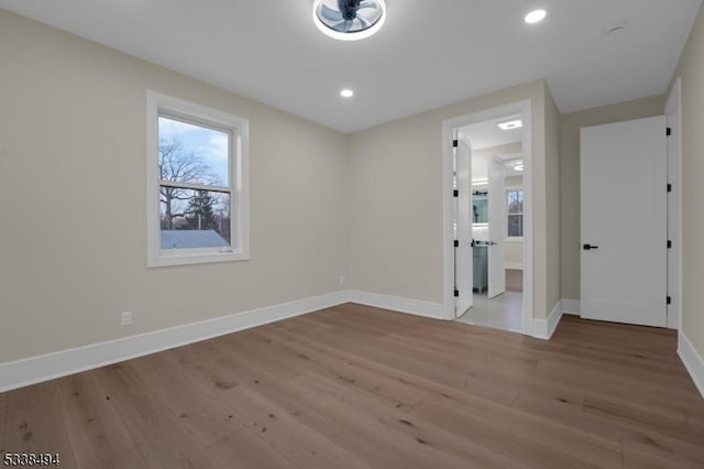 unfurnished room with baseboards, recessed lighting, and wood finished floors