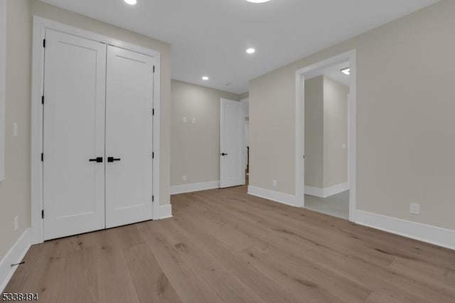 unfurnished bedroom with baseboards, recessed lighting, a closet, and light wood finished floors