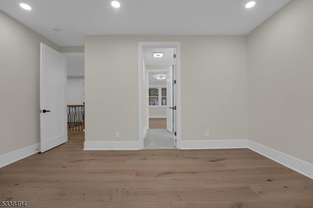 unfurnished room with recessed lighting, baseboards, and light wood-style floors
