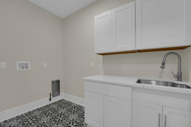 laundry area with hookup for a washing machine, a sink, cabinet space, and baseboards