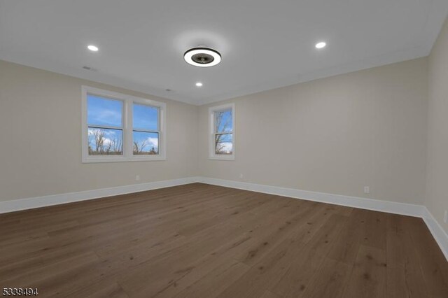 unfurnished room with recessed lighting, dark wood finished floors, and baseboards