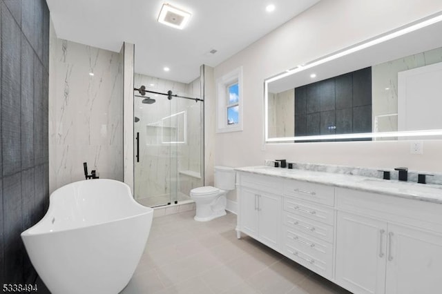 full bath featuring a sink, toilet, a stall shower, a freestanding bath, and double vanity