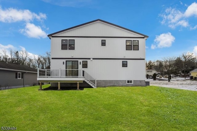 back of house featuring a lawn and a deck