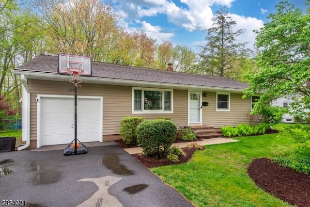 ranch-style house with a garage, cooling unit, driveway, and a front yard