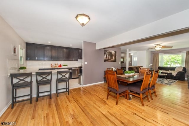dining room with baseboards, ceiling fan, and light wood-type flooring