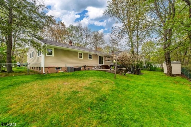 back of house with fence, a chimney, and a yard