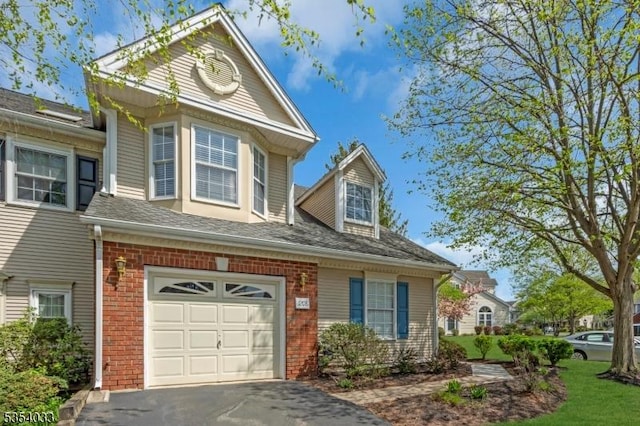 view of front of house featuring a garage, driveway, and brick siding