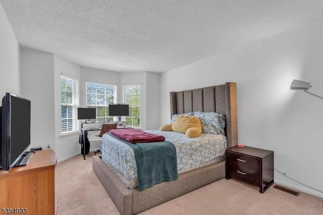 carpeted bedroom with baseboards, a textured ceiling, and visible vents
