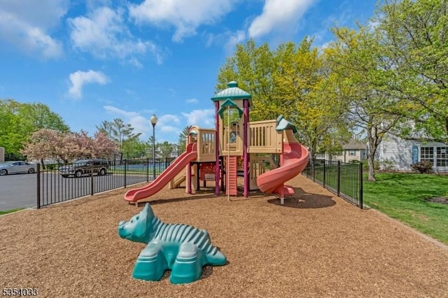 community jungle gym featuring a lawn and fence