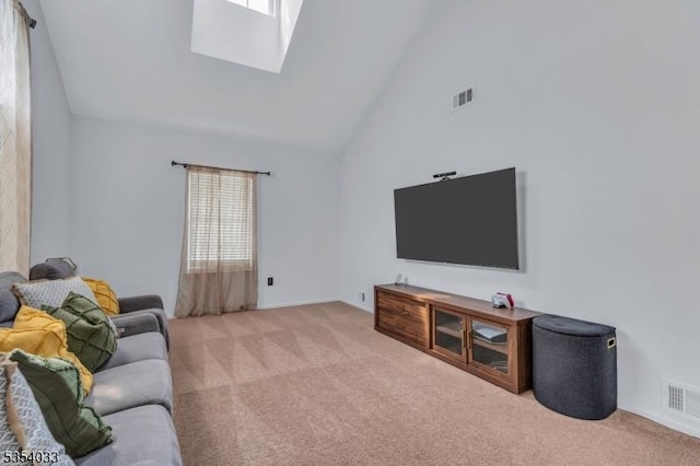 living area featuring carpet floors, high vaulted ceiling, visible vents, and a skylight