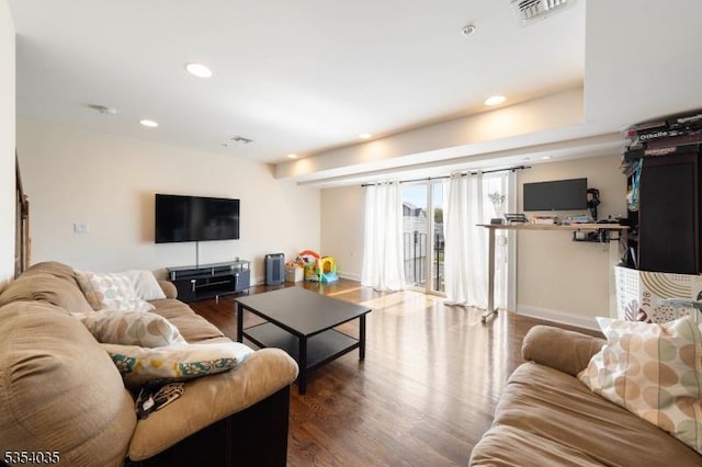 living area featuring baseboards, recessed lighting, wood finished floors, and visible vents