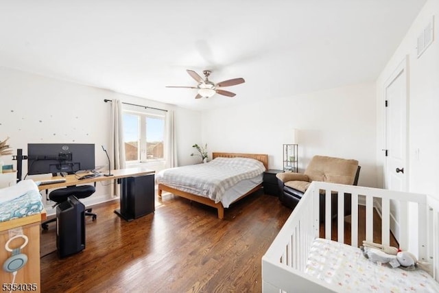 bedroom with visible vents, a ceiling fan, and dark wood-style floors