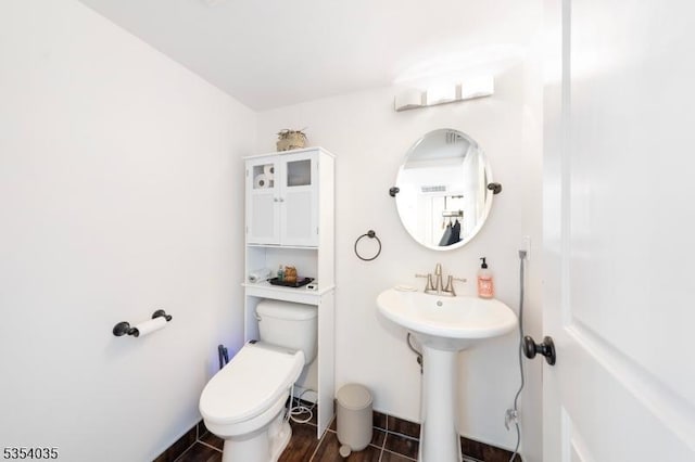 bathroom featuring a sink, toilet, and wood finished floors