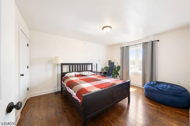 bedroom with baseboards and wood finished floors