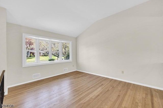empty room featuring baseboards, visible vents, and wood finished floors