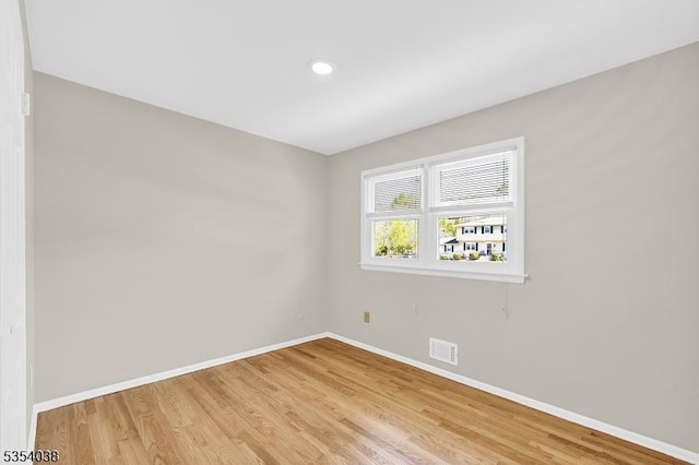 spare room with recessed lighting, baseboards, light wood-type flooring, and visible vents