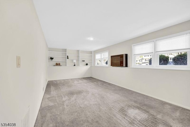 carpeted spare room featuring baseboards
