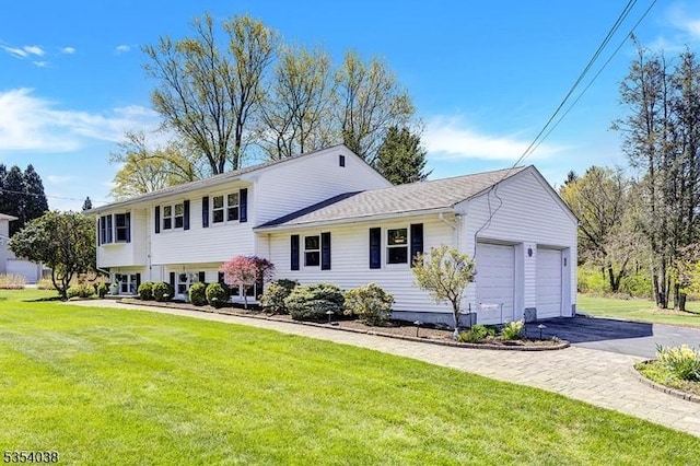 split level home featuring a garage, driveway, and a front lawn