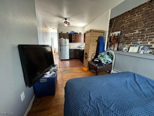 bedroom featuring freestanding refrigerator, a ceiling fan, and wood finished floors