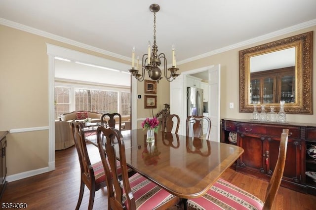 dining room with an inviting chandelier, baseboards, ornamental molding, and dark wood finished floors