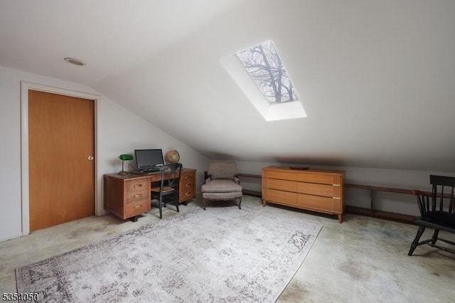 office with light carpet and vaulted ceiling with skylight