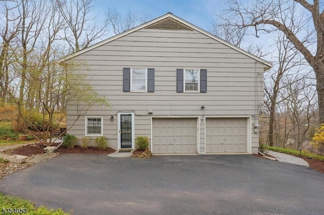 view of front of property featuring an attached garage and aphalt driveway