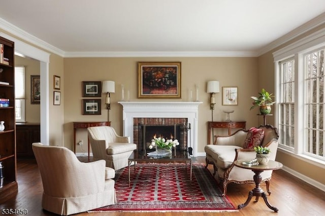 sitting room featuring ornamental molding, wood finished floors, and a fireplace