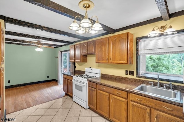 51 Meggins Rd, Rockaway Twp, NJ 07866 - kitchen with white range with gas stovetop, beam ceiling, dark countertops, light tile patterned floors, and a chandelier