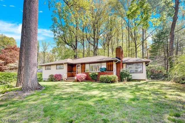 single story home with a chimney and a front lawn