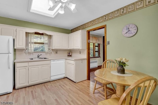 kitchen with white appliances, ceiling fan, light countertops, white cabinetry, and a sink