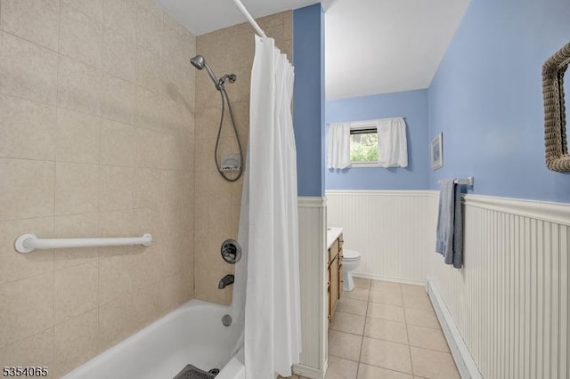 bathroom featuring vanity, wainscoting, toilet, tile patterned floors, and shower / bath combo