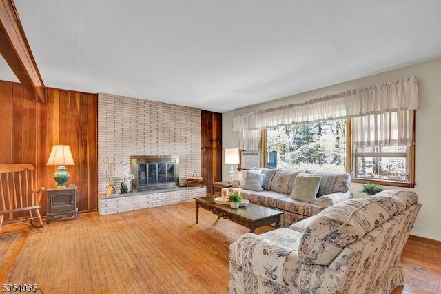 living area featuring a wood stove, a fireplace, and hardwood / wood-style floors