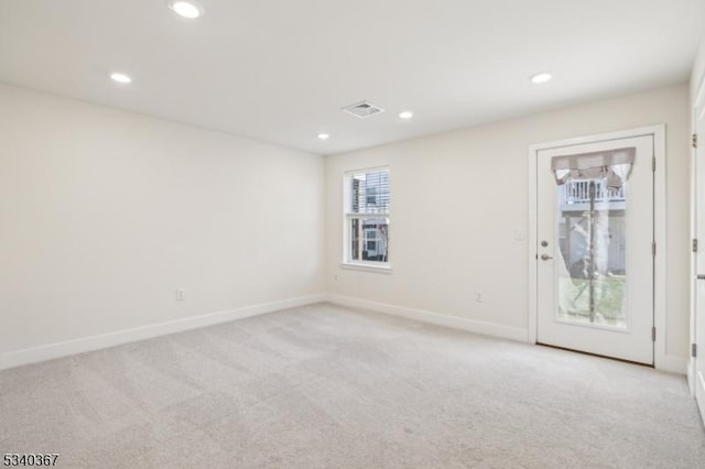 spare room with recessed lighting, baseboards, visible vents, and light carpet