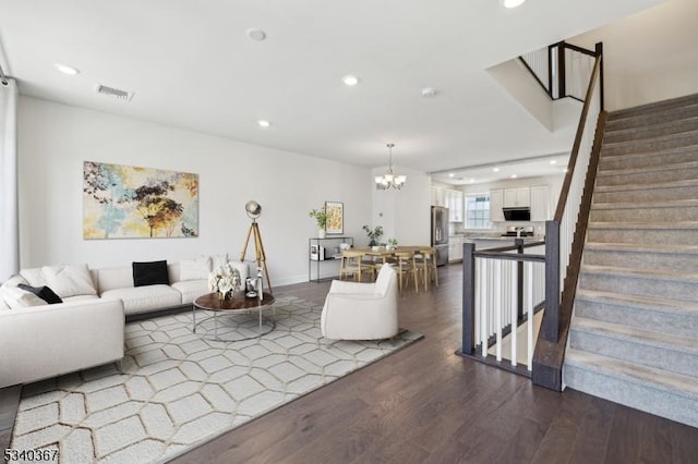 living room with dark wood-style flooring, visible vents, stairs, a chandelier, and recessed lighting