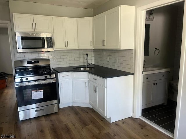 914 S St, Elizabeth City, NJ 07202 - kitchen with white cabinets, dark countertops, appliances with stainless steel finishes, a sink, and dark wood-type flooring