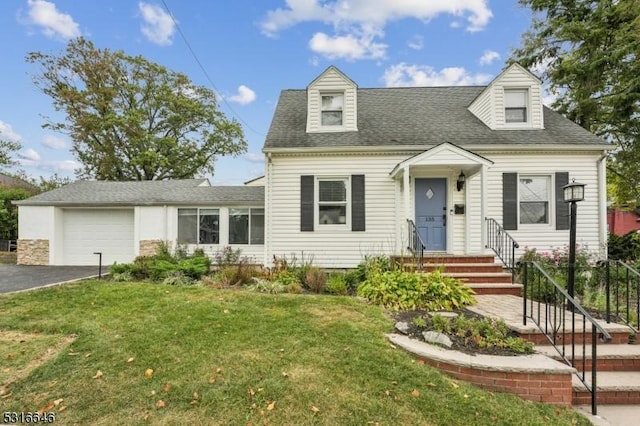cape cod home with a garage, driveway, roof with shingles, and a front yard