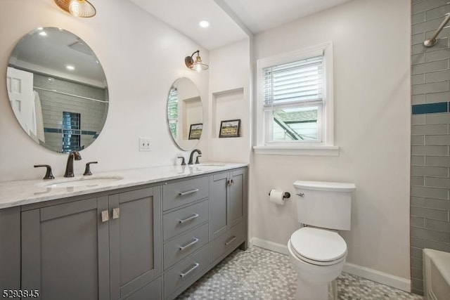full bathroom with a sink, double vanity, toilet, baseboards, and a shower