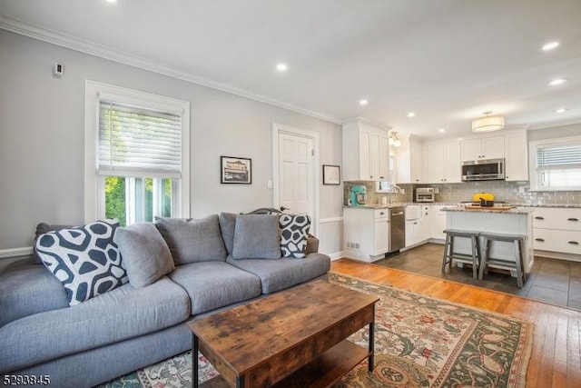living area with crown molding, recessed lighting, and hardwood / wood-style flooring