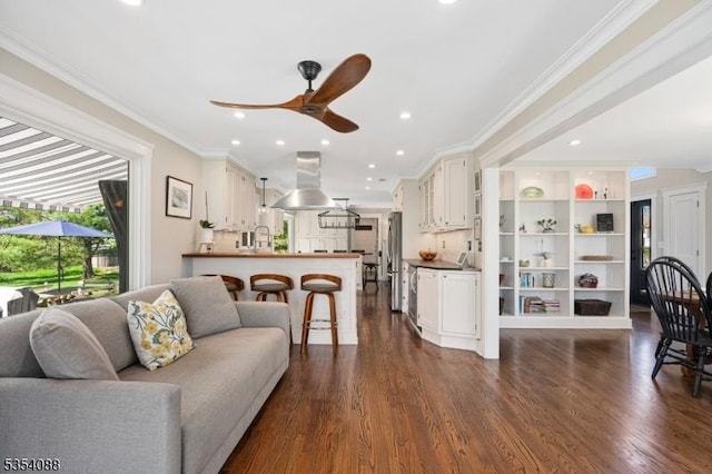 living room featuring dark wood-type flooring, a ceiling fan, recessed lighting, and ornamental molding
