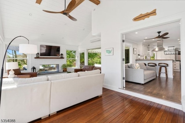 living area featuring wood-type flooring, a fireplace, beamed ceiling, recessed lighting, and a ceiling fan